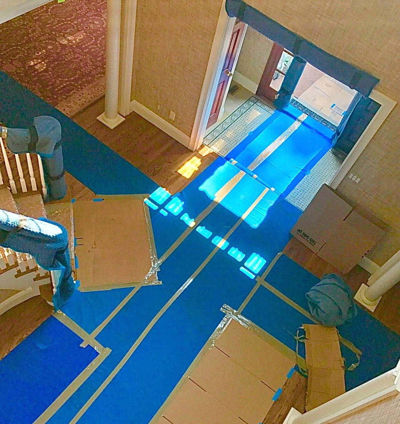 The same hardwood floors, entryway and stairs fully covered with protective runners